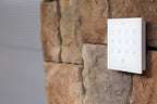 Loxone NFC Code Touch in white on a stone wall