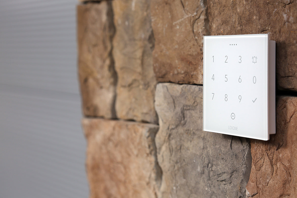 Loxone NFC Code Touch in white on a stone wall